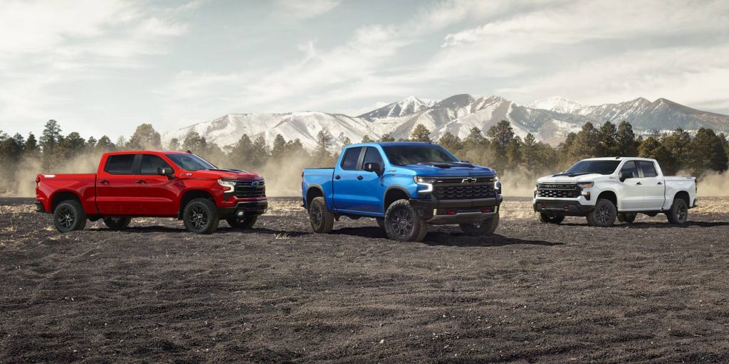 Three Chevy Silverado's outdoors