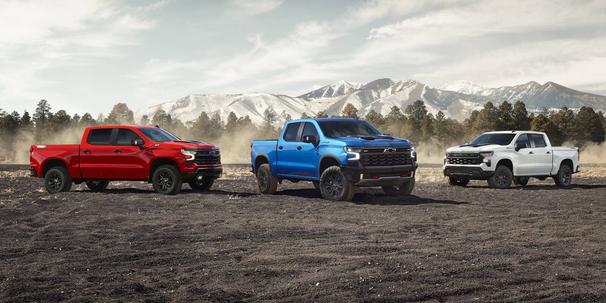 Three Chevy Silverado's outdoors